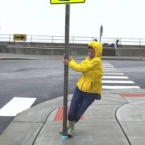 Una mujer lucha contra el viento.