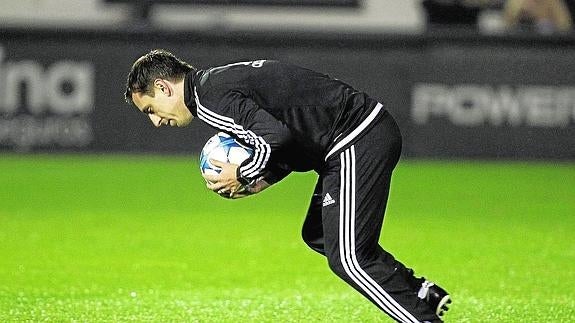Gary Neville recoge un balón en un entrenamiento con el Valencia.