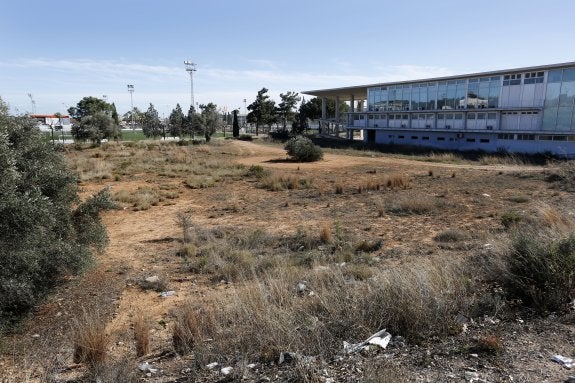 El solar que interesa al Valencia con la ciudad deportiva al fondo y el edificio del Centro de Tecnologías Limpias, ahora vacío. 