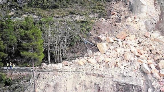 Tres operarios, junto al derrumbe de la montaña de Corte de Pallás, ocurrido en abril del año pasado.