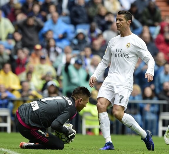 Alves atrapa el balón ante Cristiano Ronaldo.
