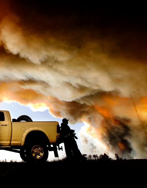 Un bombero se toma un descanso mientras contempla el fuego que ha arrasado la ciudad canadiense de Fort McMurray, que sigue sin poder ser controlado. :: reuters