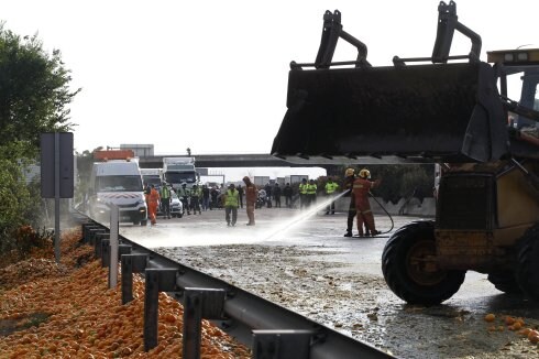 Bomberos en la zona, con naranjas caídas del camión. :: irene marsilla