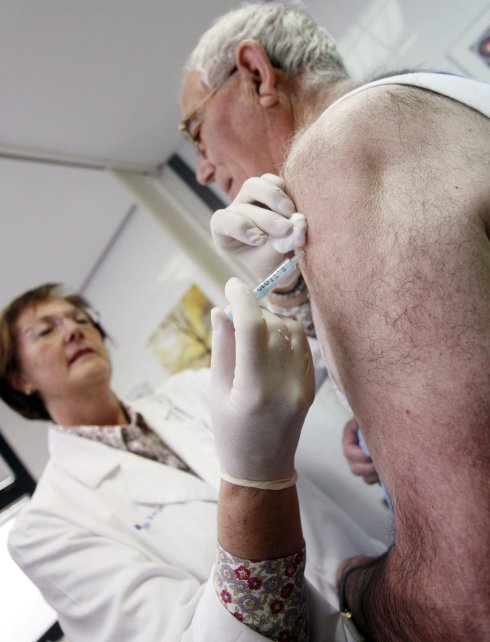 Un hombre recibe una vacuna en un centro de salud. :: AFP