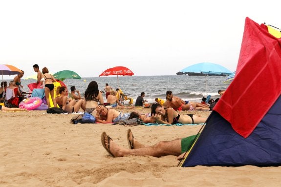 Varios bañistas toman el sol en la playa.