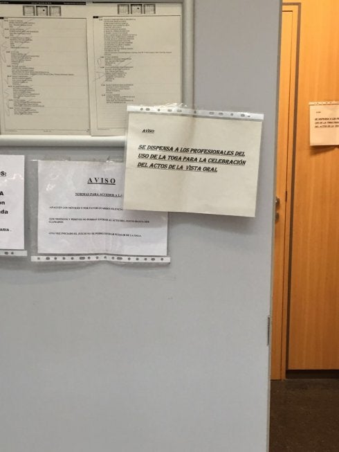  Cartel informativo. Un aviso a las puertas de un juzgado indica a los letrados que pueden acudir sin toga. :: lp