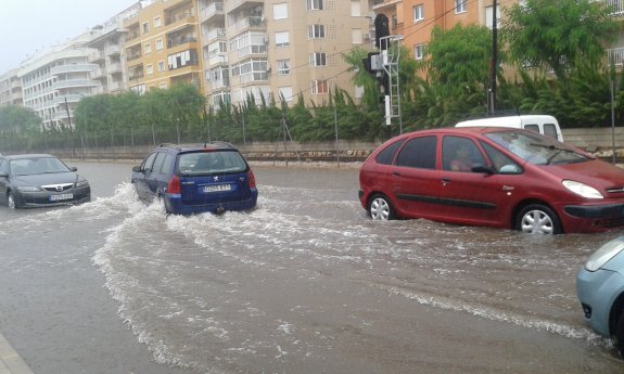 Los coches circulan por la avenida Joan Fuster de Dénia, inundada por la lluvia. :: tino calvo