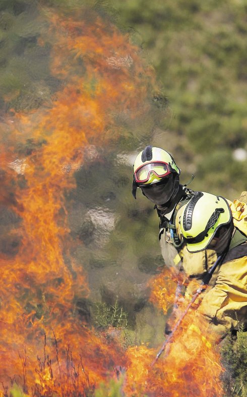 Un bombero forestal lucha contra el fuego en Carcaixent. :: efe