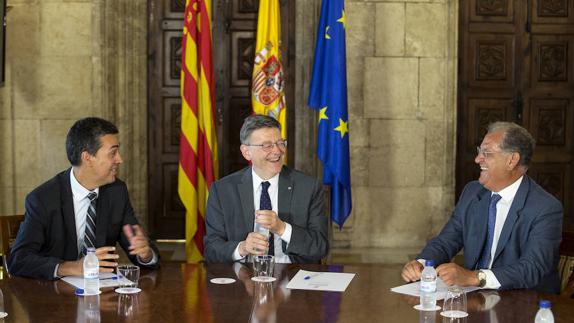 El president de la Generalitat, Ximo Puig (centro), bormea con el presidente de Ford Europa, Andrew McCall (izqda), y de Ford España, José Manuel Machado, al comienzo de la reunión en el Palau de la Generalitat. 