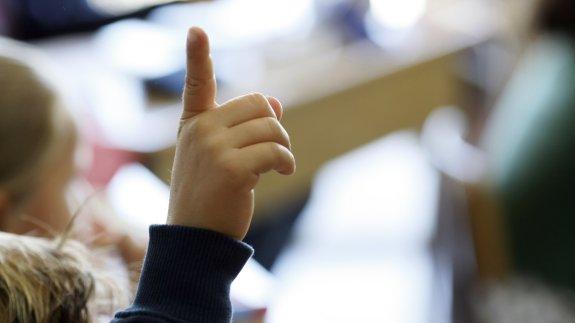Un niño, pidiendo permiso para intervenir en clase.