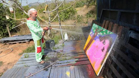 El artista limpia, manguera en mano, uno de los cuadros a la conclusión de la entrevista eralizada en Mas de Flors.