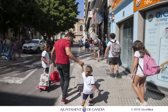 Un padre recoge a sus hijos de un céntrico colegio de Gandia. :: ÀLEX OLTRA