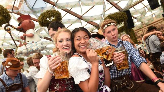 Tres jóvenes disfrutan de una jornada en la Oktoberfest de Alemania.