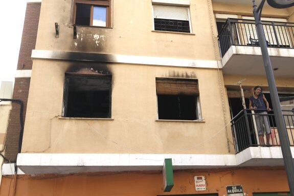 Una mujer asomada a un balcón del primer piso de la casa donde se declaró el incendio. :: manuel molines
