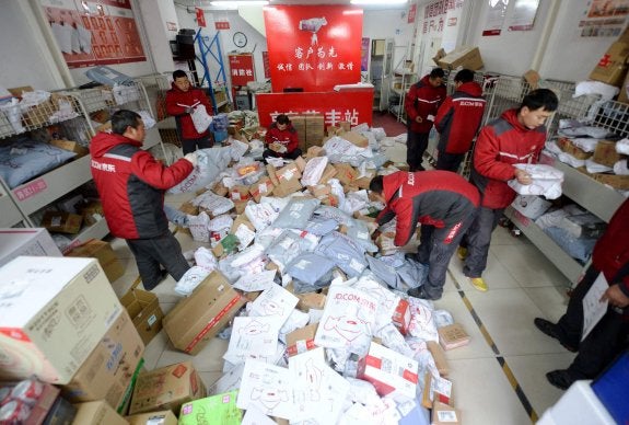 Trabajadores de una oficina de Correos de Pekín se preparan para la avalancha de envíos del Día de los Solteros. :: afp