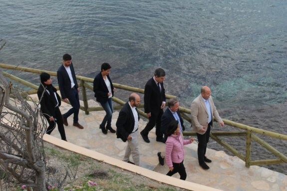 Una comitiva local acompaña al delegado del Gobierno, Juan Carlos Moragues, en su visita a la cala. :: LP