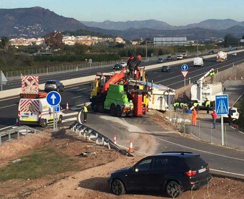 Una grúa intenta levantar el camión volcado. 
