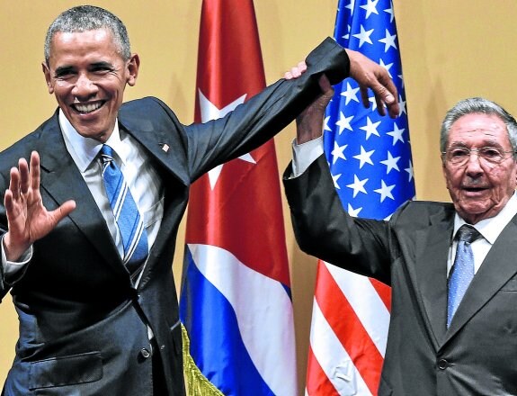 Raúl Castro levanta el brazo de Barack Obama en un gesto de cordialidad, en un acto celebrado en marzo de 2016 en el Palacio de la Revolución de La Habana. :: afp