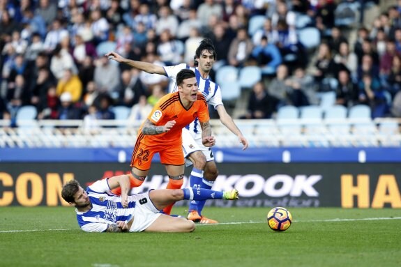 Iñigo Martínez derriba a Santi Mina en el penalti que supuso el primer tanto del Valencia en el encuentro. :: EFE/Juan Herrero