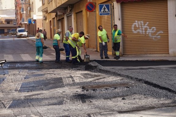 Operarios asfaltando una calle de Paterna. :: lp