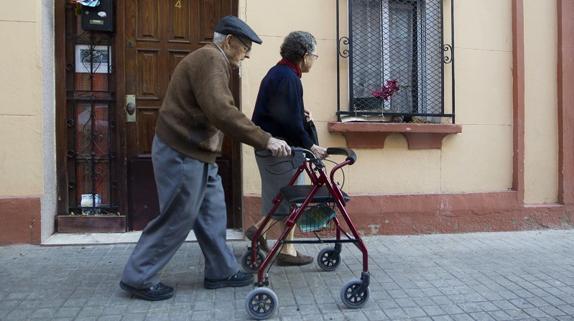 Dos ancianos pasean por un calle de Valencia.