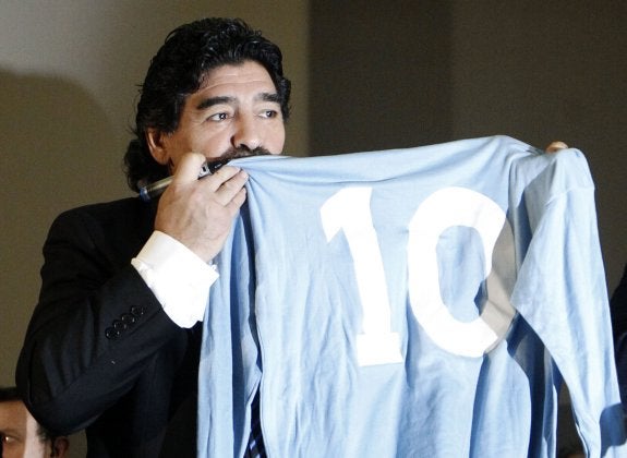 Maradona muestra su camiseta del Nápoles, con el legendario 10 a la espalda. :: REUTERS