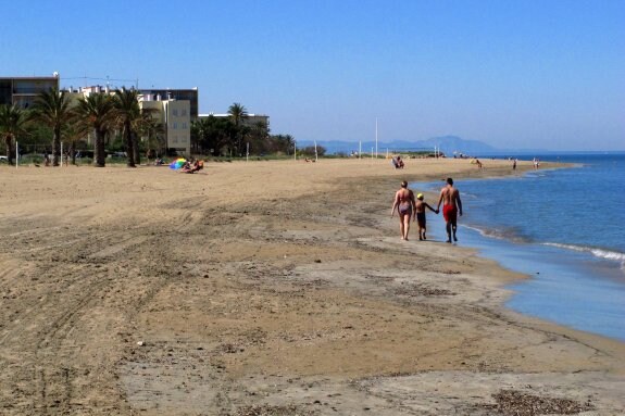 Unos bañistas pasean por una playa de Valencia. :: lp