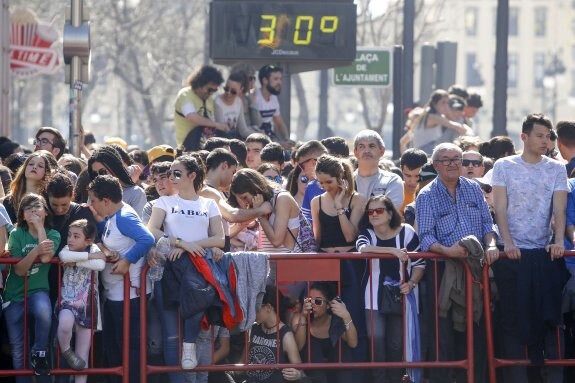 Gente esperando la mascletà ante un termómetro que marca 30 grados. :: manuel molines