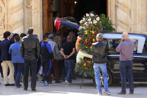 Un grupo de personas junto al coche fúnebre en la puerta de la iglesia de Santa Catalina de Alzira. :: manuel molines