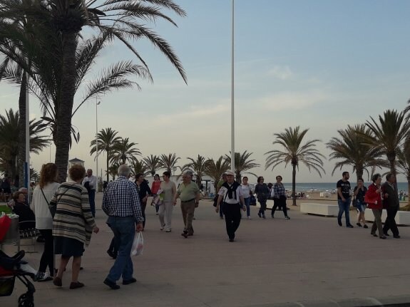 Turistas caminando por el paseo marítimo de la playa de Gandia el pasado Viernes Santo. :: rocío escrihuela