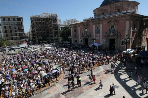 Vista general de la plaza de la Virgen, con los paraguas abiertos por los asistentes para protegerse del sol. :: irene marsilla
