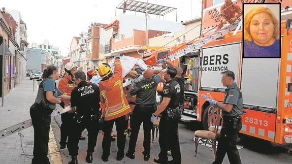 Bomberos, policías locales y guardias civiles bajan a la víctima con una escalera a la calle para trasladarla a la ambulancia. :: lp