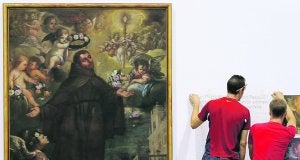 Técnicos preparando ayer 'San Pascual Bailón', de Esteban Sala, para 'Restaura. 15 años recuperando nuestro patrimonio', que hoy se inaugura en Valencia. ::                             JUANJO MONZÓ