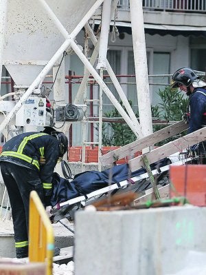 Los bomberos sacan el cadáver del trabajador fallecido. ::
J. P. REINA