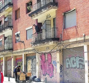 Una de las personas que habita en el edificio observa a un compañero desde el balcón. ::                             TONI BLASCO
