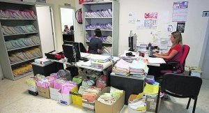 Funcionarios del juzgado de Alzira trabajan entre montañas de papeles