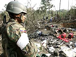 Un soldado ecuatoriano observa los cadáveres de guerrilleros de las FARC abatidos en Angostura junto al número dos de la guerrilla.
