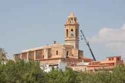Una grúa vuelve a instalar las campanas de la iglesia parroquial, ayer.
