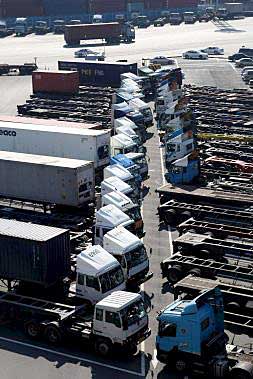 Decenas de camiones esperan carga de trabajo en un puerto.