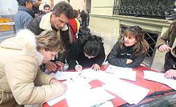 Inmigrantes rumanos rellenan impresos en la Delegación del Gobierno de Valencia.