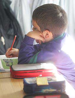 Un niño toma notas durante el transcurso de una clase.
