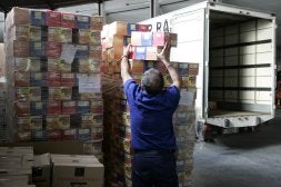 Un operario descarga paquetes de productos alimenticios en el Banco de Alimentos de Castellón.PAU BELLIDO