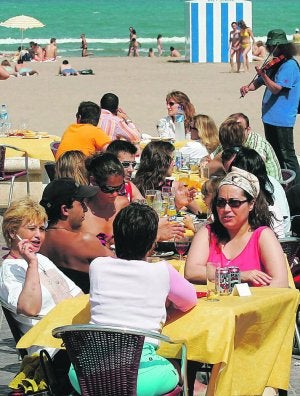 OCIO. Varios turistas disfrutan de un chiringuito. / D. TORRES