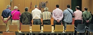 LOS NUEVE APÓSTOLES DE LA EXTORSIÓN. Los nueve transportistas procesados por faltas de coacciones y lesiones, el 3 de noviembre de este año, en una sala de la Ciudad de la Justicia de Valencia. /MIKEL PONCE
