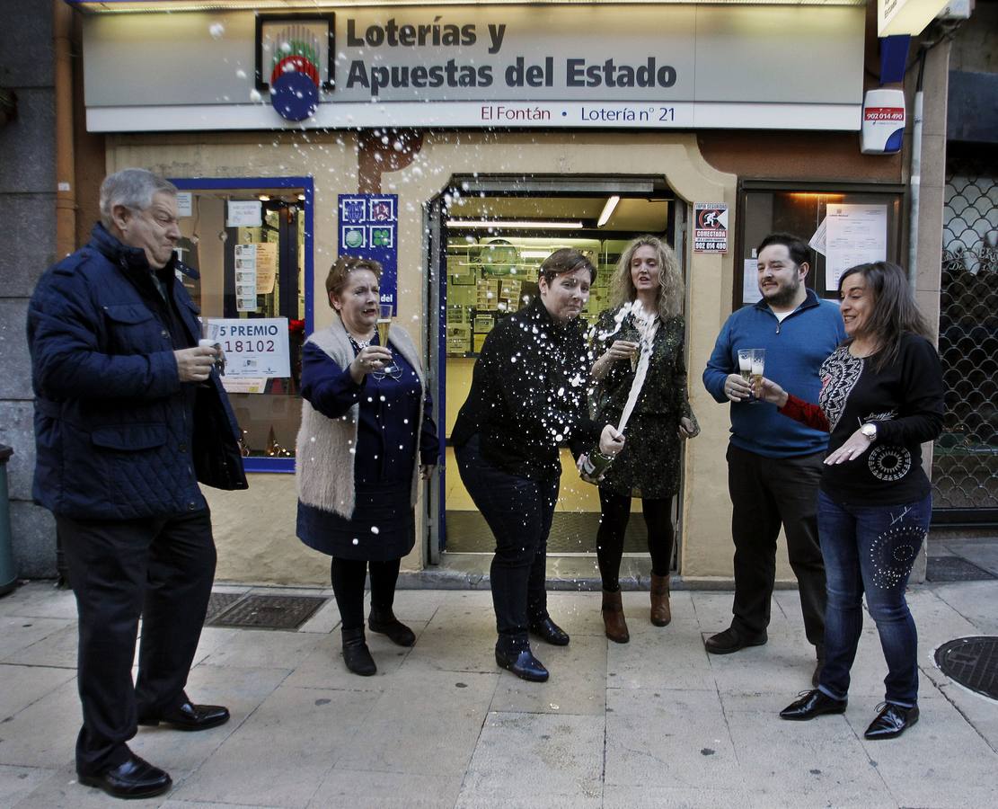 Carmen Llorente (2i), propietaria de la administración número 21 de Oviedo y los empleados de la oficina, donde se ha vendido el 18.102, agraciado con un quinto premio.