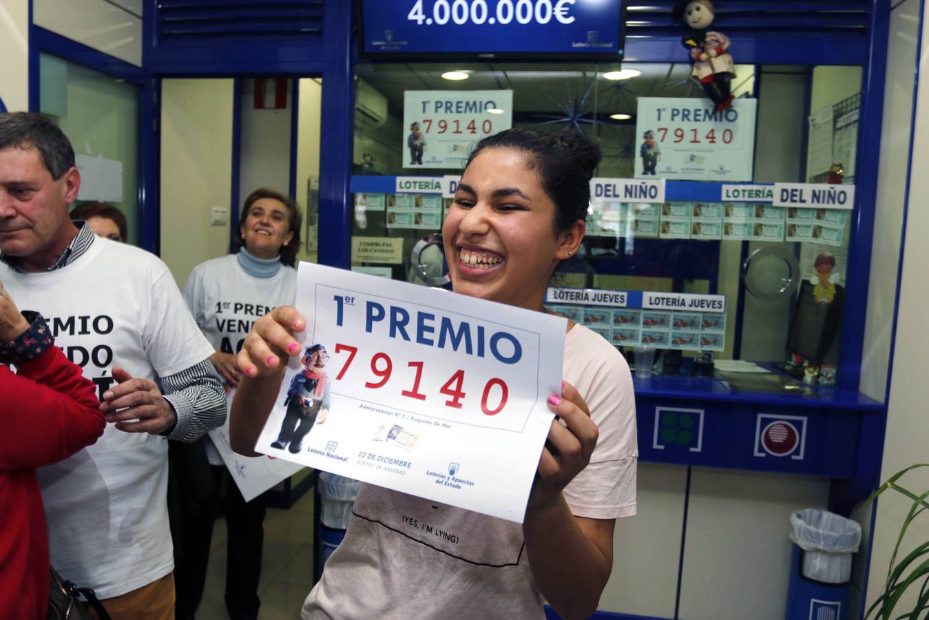 Una joven sonríe con una copia del número 79140, agraciado con el Gordo de Navidad del Sorteo Extraordinario de la Loteria celebrado hoy y vendido íntegramente en la administracion nº 2 de Roquetas de Mar (Almería).