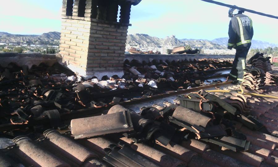 Los bomberos recogen tejas que se han desplazado por el viento.