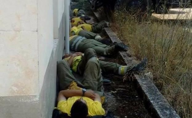 Foto tomada el pasado lunes en la que se ve el cansancio de los bomberos que se encuentran luchando contra el incendio.