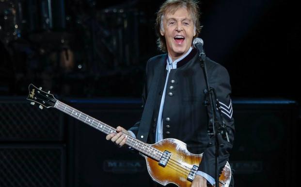 McCartney toca la guitarra en un concierto. 