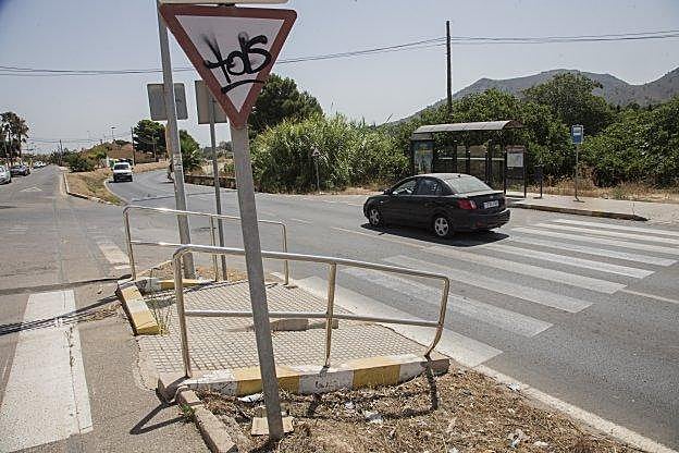 Paso de peatones junto al restaurante Sacromonte, con la curva al fondo. Abajo, un coche frena para pasar por encima de un resalte.
